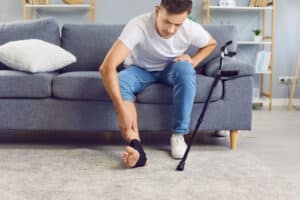 man sitting on the couch with a ligament injury to his knee